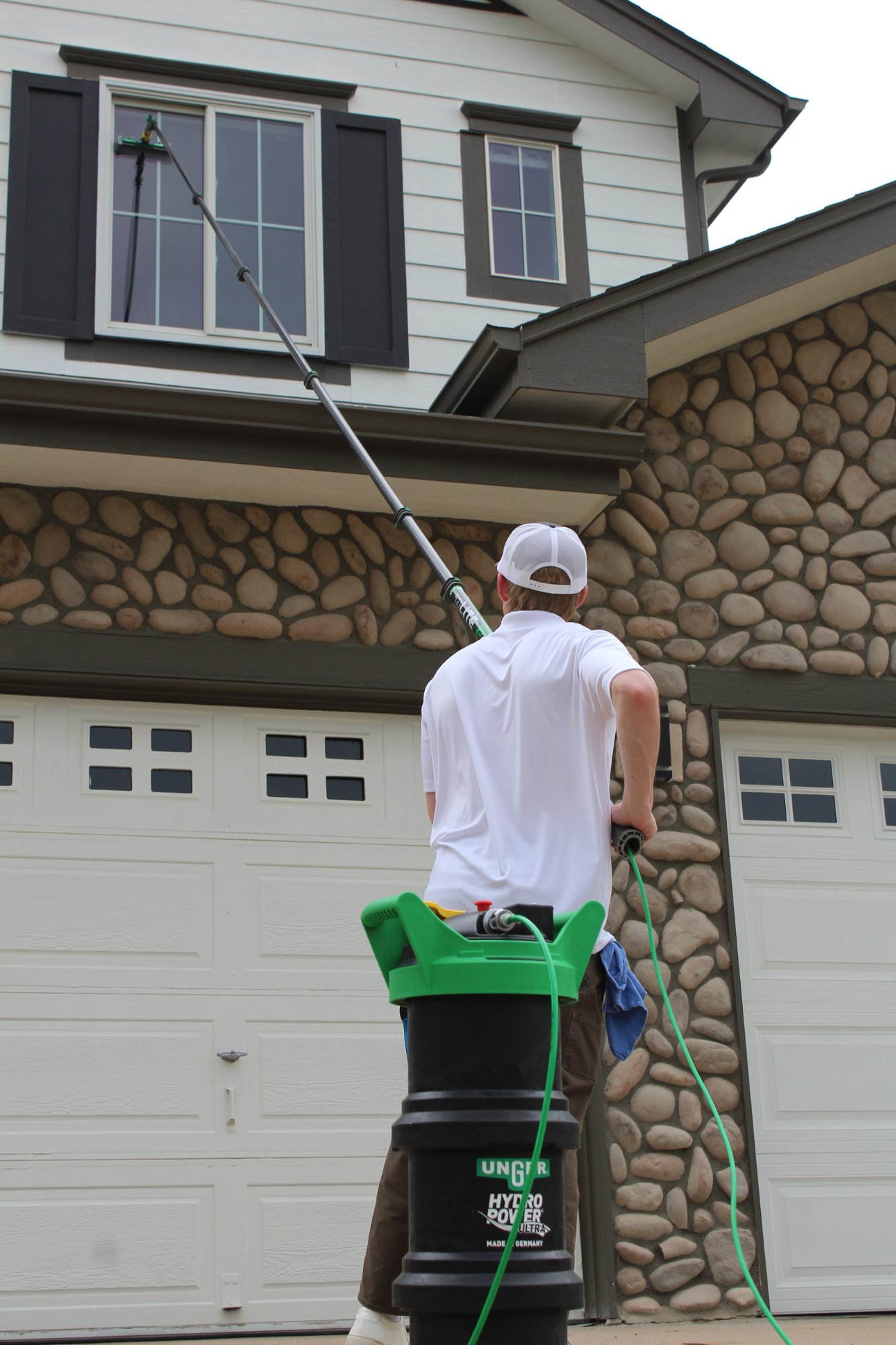 Water-fed pole on stone facade home